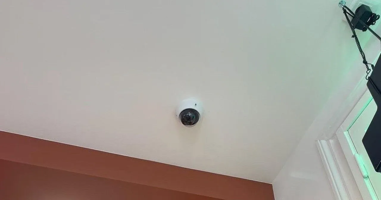 Caméra dôme dans un bureau, au-dessus d'une fenêtre à stores