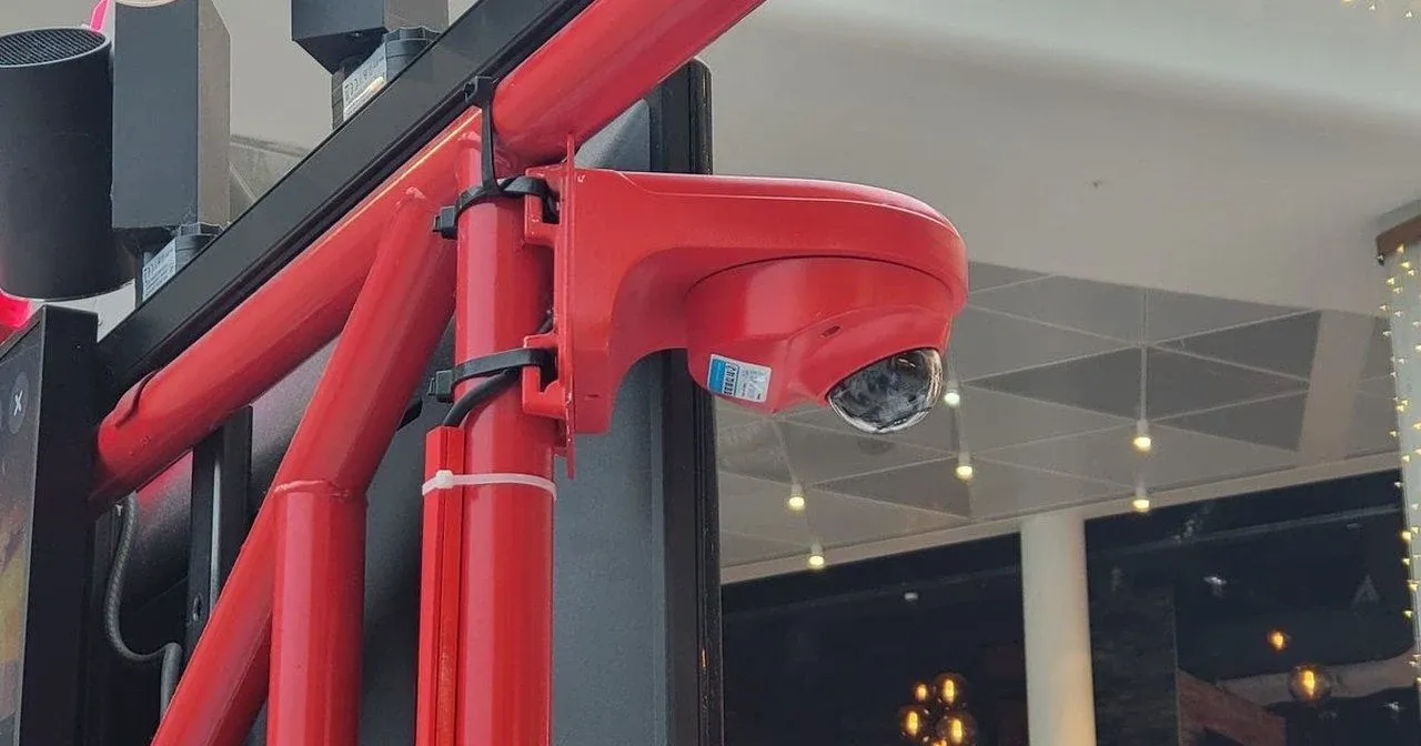 Caméra dôme fixée sur la structure d'un stand de restauration, en centre commercial