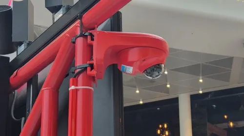 Caméra dôme fixée sur la structure d'un stand de restauration, en centre commercial