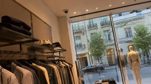 Vitrine d'une boutique parisienne vue de l'intérieur, avec un détecteur de bris de glace fixé au plafond