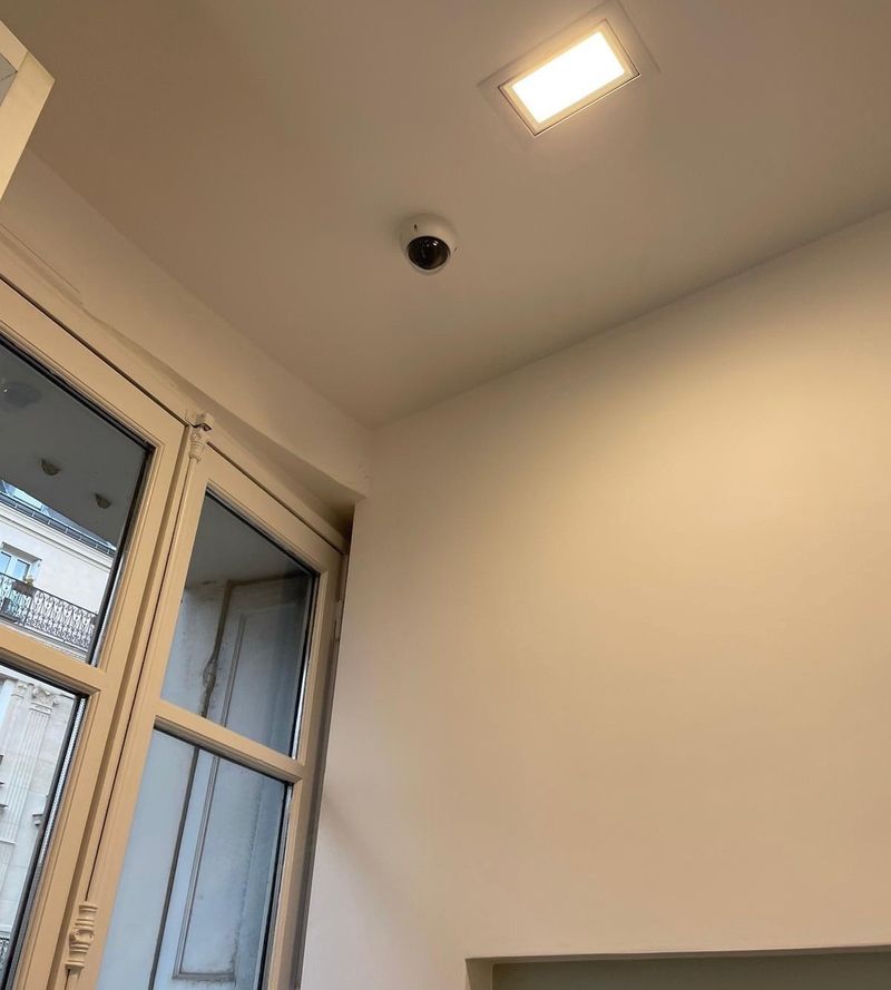 Caméra dôme posée au plafond d'une cage d'escalier d'immeuble haussmannien