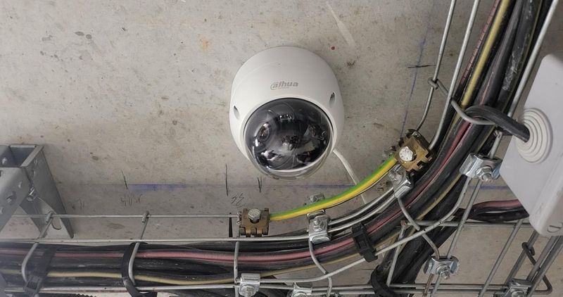 Caméra dôme posée entre les chemins de câbles d'un local technique