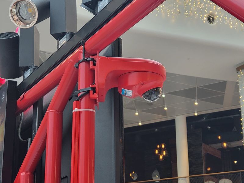 Caméra dôme fixée sur la structure d'un stand de restauration, en centre commercial