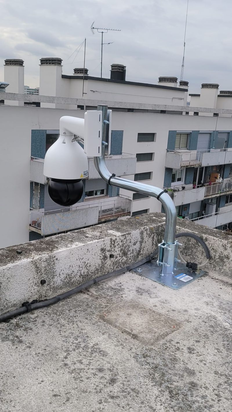 Caméra motorisée orientable posée sur une potence, sur un toit-terrasse