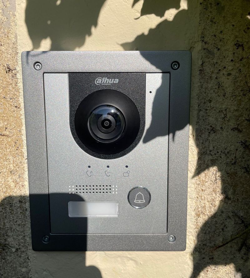 Platine de portier vidéo Dahua posée sur un mur en pierre, à l'entrée d'une propriété